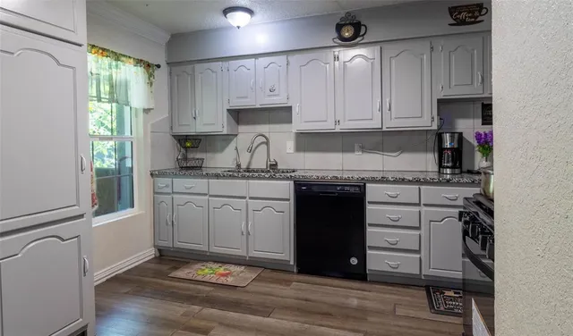 a kitchen with granite countertop white cabinets and white appliances