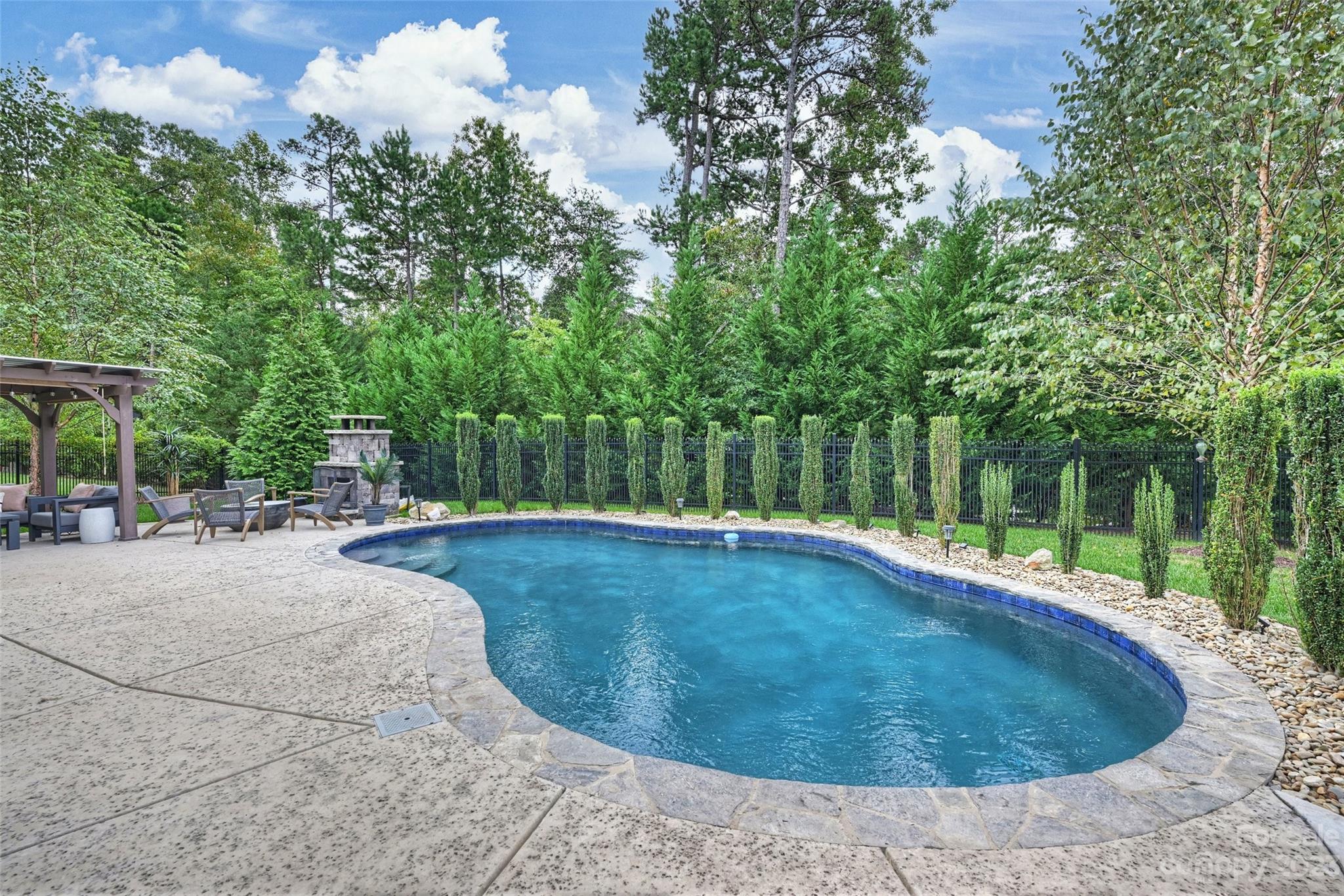 658 Zinnia Way Tega Cay, SC 29708 - Photo 1 of 32 a swimming pool with outdoor seating and yard