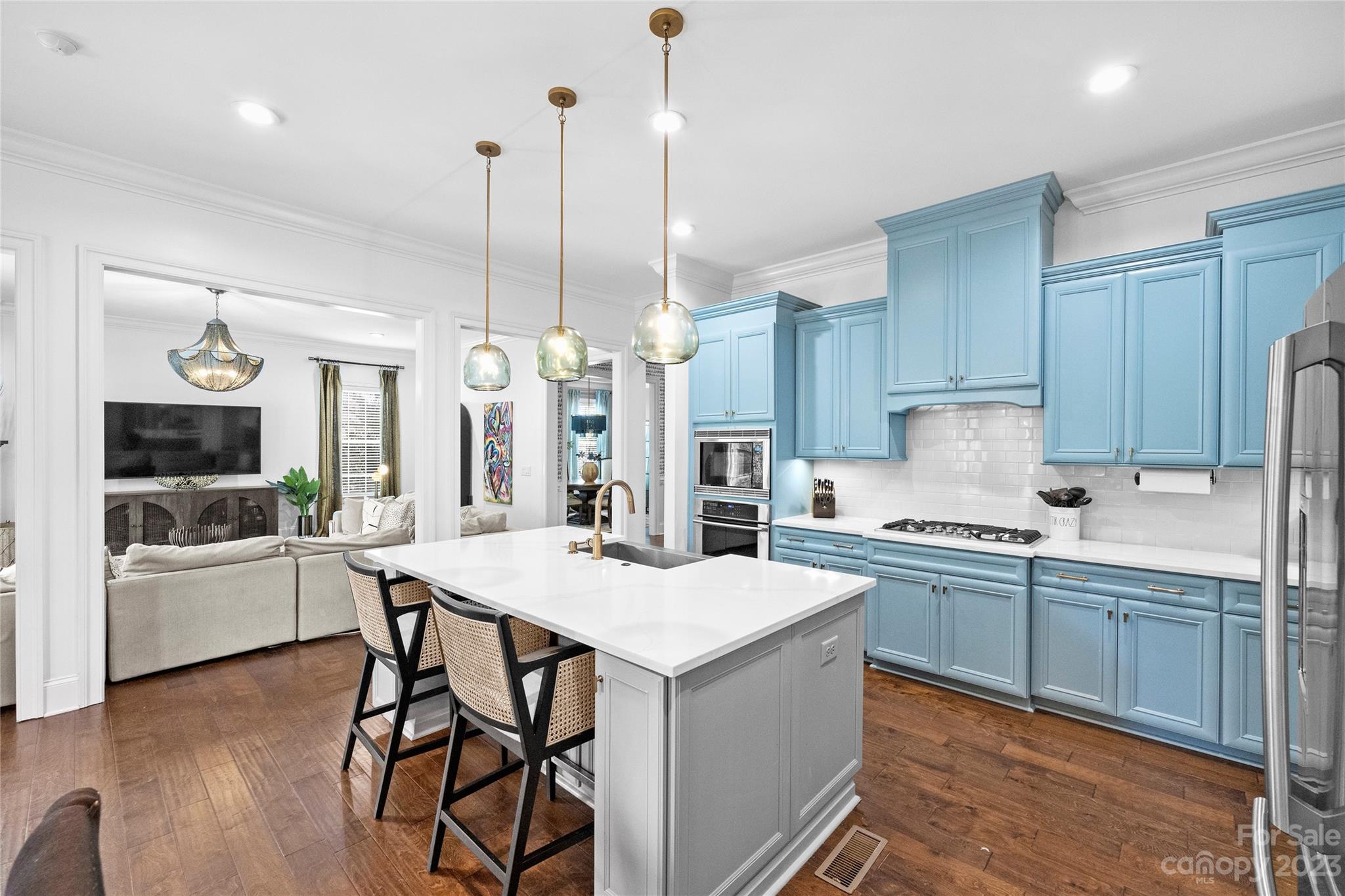 658 Zinnia Way Tega Cay, SC 29708 - Photo 11 of 32 a kitchen with stainless steel appliances a stove a sink a kitchen island with chairs and wooden cabinets
