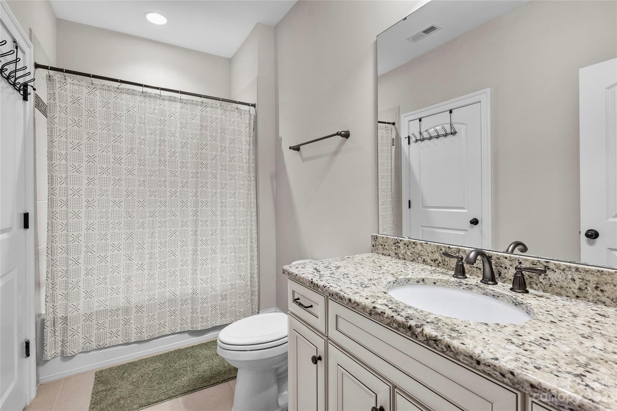 658 Zinnia Way Tega Cay, SC 29708 - Photo 25 of 32 a bathroom with a granite countertop sink toilet and shower