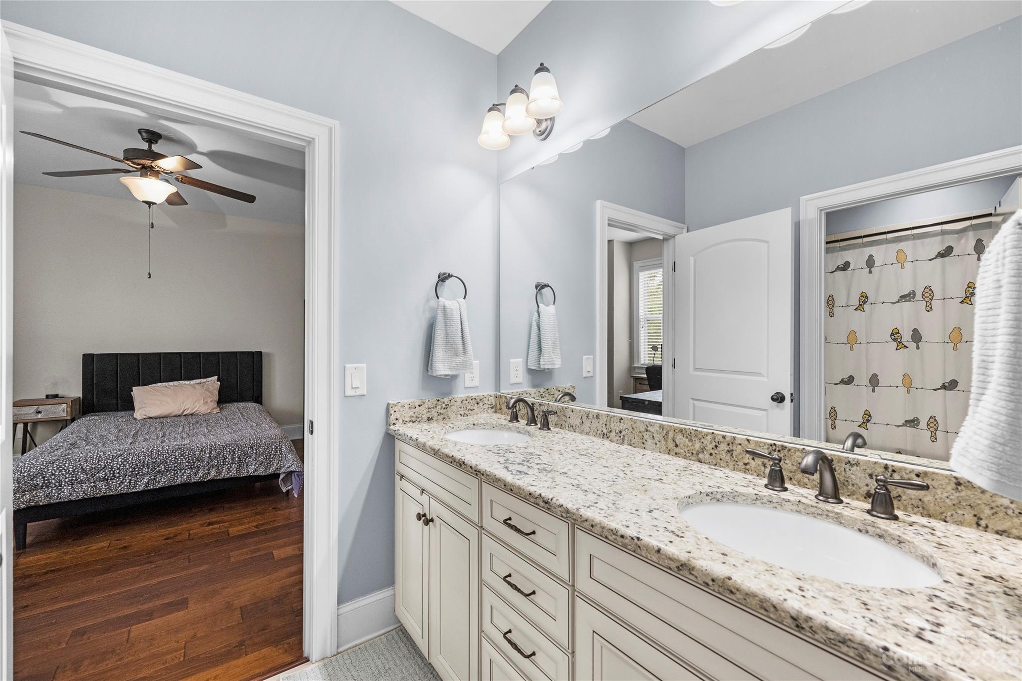 658 Zinnia Way Tega Cay, SC 29708 - Photo 28 of 32 a bathroom with a granite countertop double vanity sink and a mirror