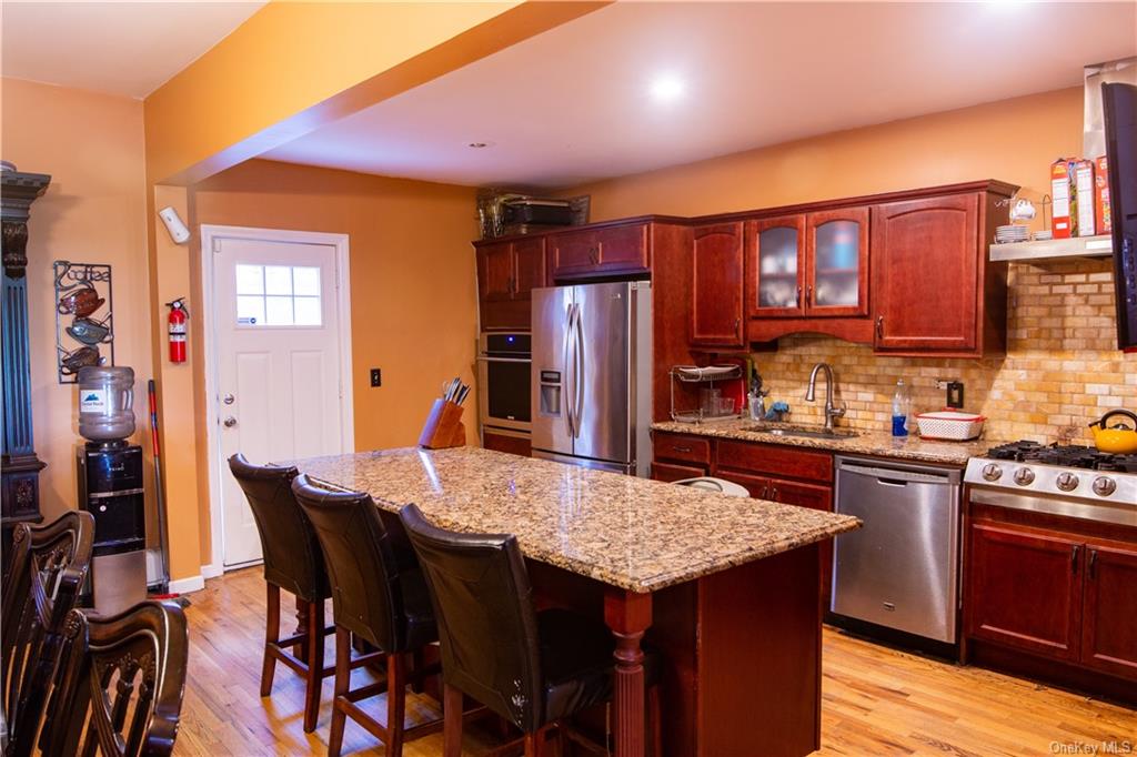 a kitchen with stainless steel appliances granite countertop a kitchen island a table and chairs