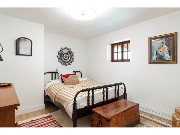 a bedroom with a bed and a painting on the wall