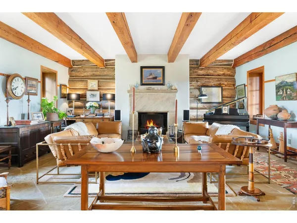 a living room with fireplace furniture and a large window