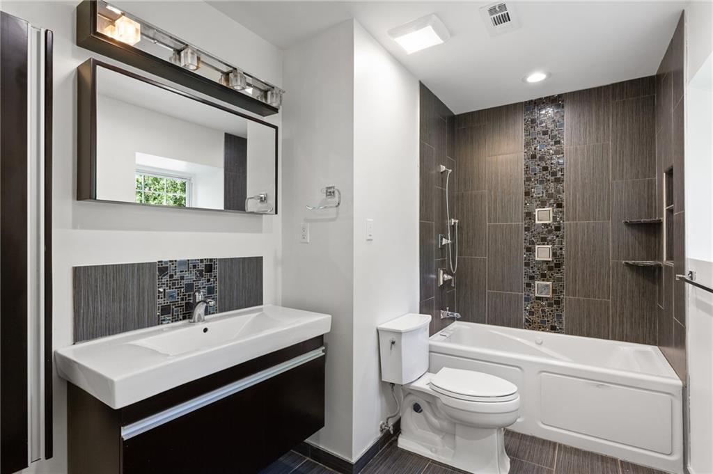 1261 Lavista Road Northeast, Unit C3 Atlanta, GA 30324 - Photo 13 of 34 a bathroom with a sink toilet a mirror and shower