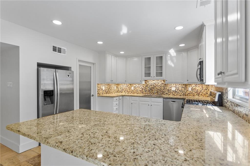 1261 Lavista Road Northeast, Unit C3 Atlanta, GA 30324 - Photo 3 of 34 a kitchen with stainless steel appliances granite countertop wooden cabinets a sink and a granite counter tops