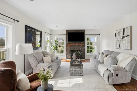 a living room with furniture a flat screen tv and a fireplace