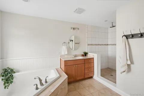 a bathroom with a tub sink and mirror