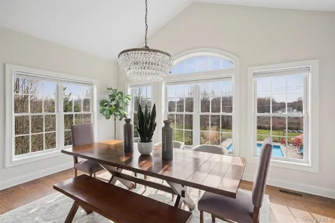 a dining room with furniture a chandelier and wooden floor
