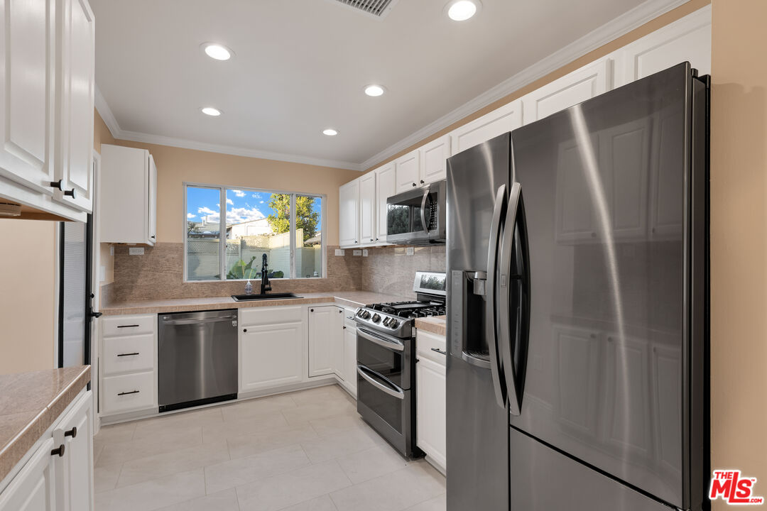 6677 West 88th Street Los Angeles, CA 90045 - Photo 6 of 23 a kitchen with stainless steel appliances granite countertop a refrigerator a stove a sink and a microwave