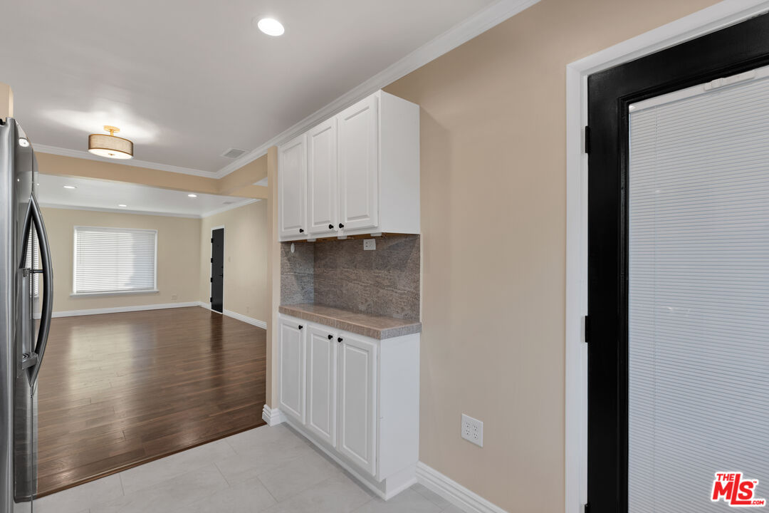 6677 West 88th Street Los Angeles, CA 90045 - Photo 9 of 23 a view of a hallway to an empty room with wooden floor and a kitchen