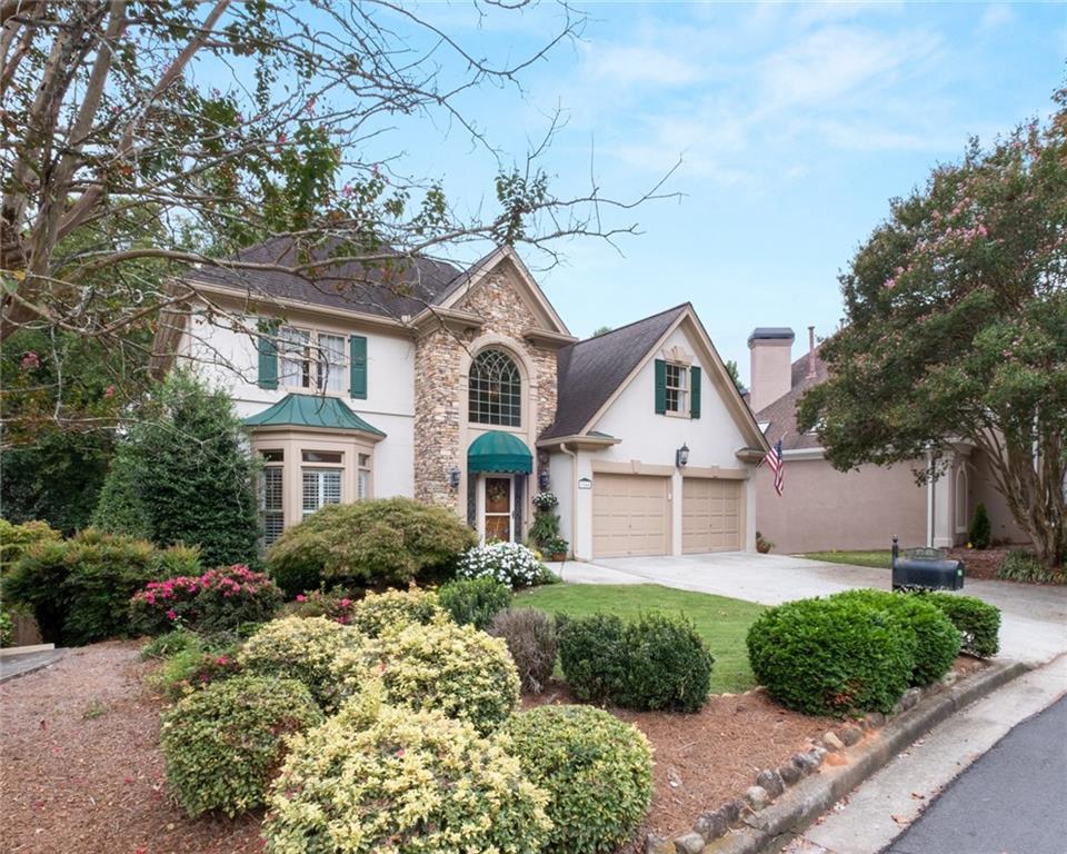 a front view of a house with a garden and plants