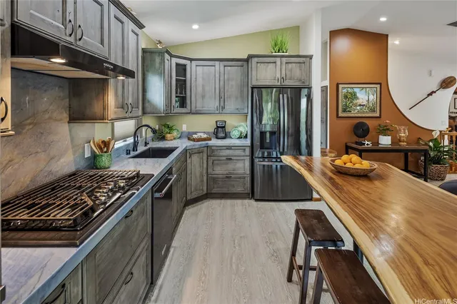 a kitchen with kitchen island a sink stove and refrigerator