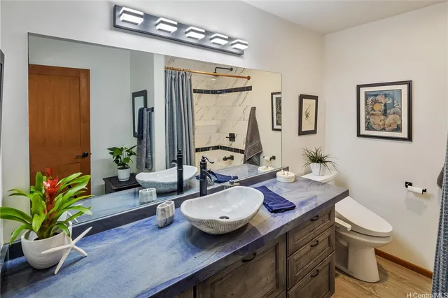 a bathroom with a granite countertop sink a toilet and a mirror