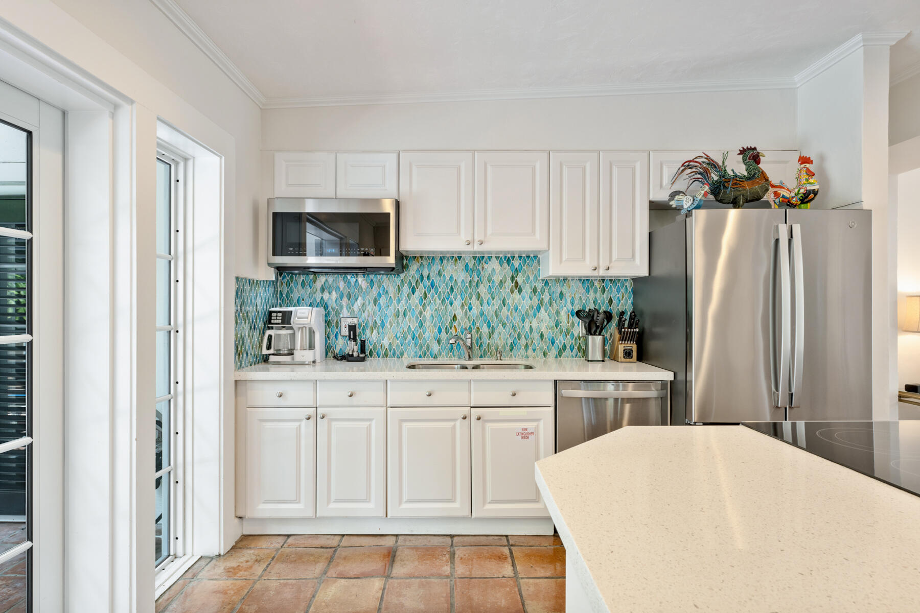 1511 Johnson Street Key West, FL 33040 - Photo 11 of 36 a kitchen with white cabinets and stainless steel appliances