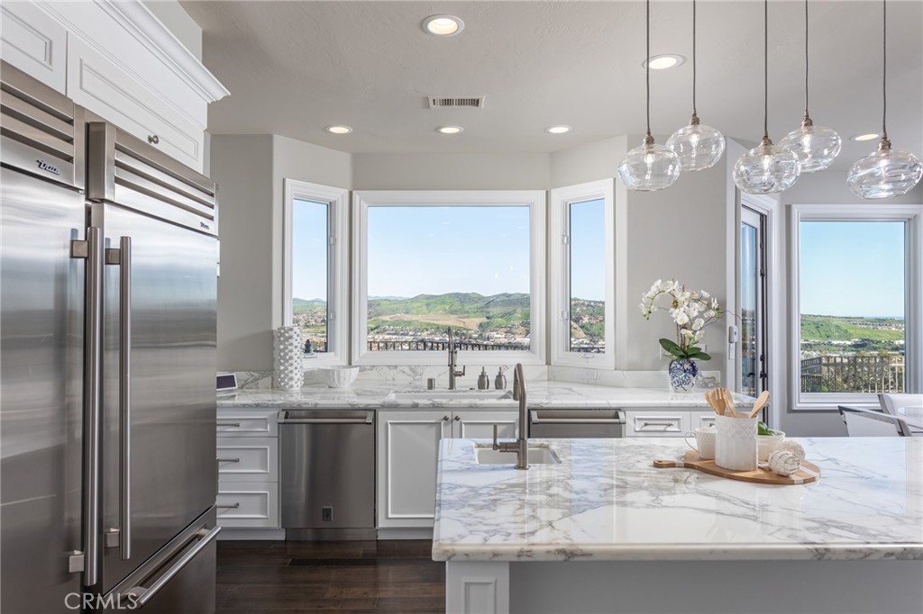 9 Wildflower Laguna Niguel, CA 92677 - Photo 13 of 47 a kitchen with kitchen island granite countertop a refrigerator a sink and a stove