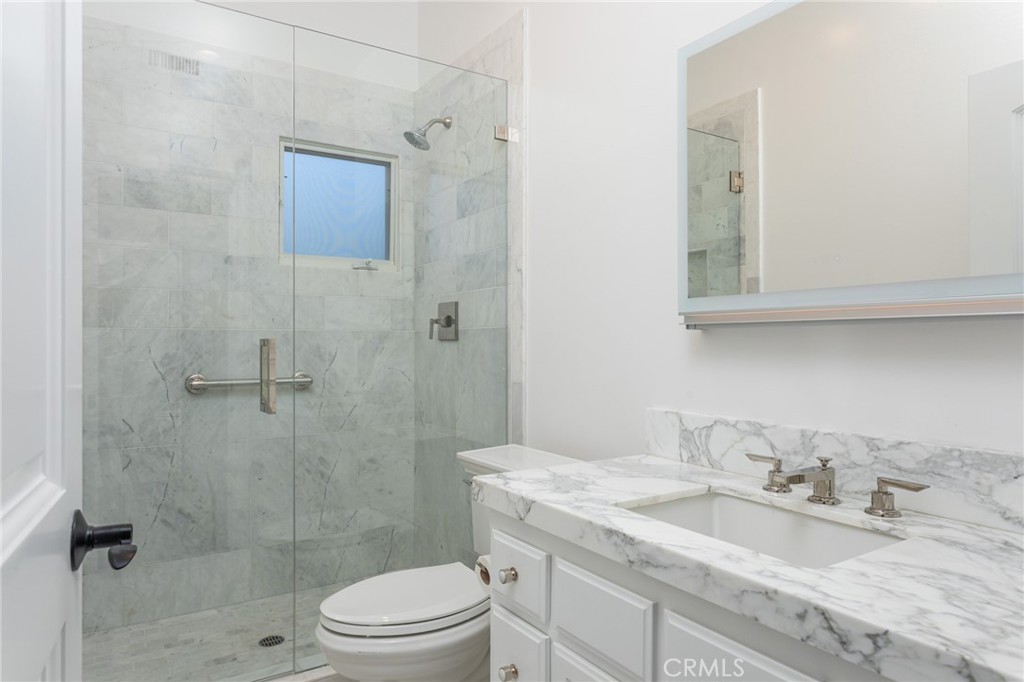 9 Wildflower Laguna Niguel, CA 92677 - Photo 25 of 47 a bathroom with a granite countertop sink a toilet and shower