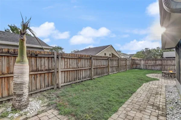 a view of a backyard with wooden fence