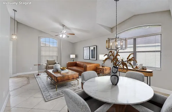 a living room with furniture a chandelier and a dining table