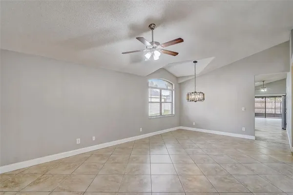 an empty room with windows and ceiling fan