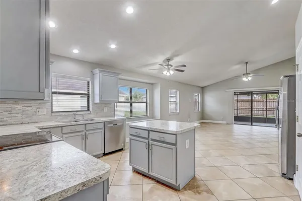 a large kitchen with kitchen island a sink stainless steel appliances and cabinets