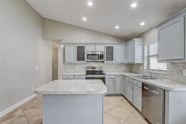 a kitchen with stainless steel appliances granite countertop a stove top oven a sink and dishwasher