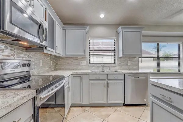 a kitchen with stainless steel appliances granite countertop a sink stove and cabinets