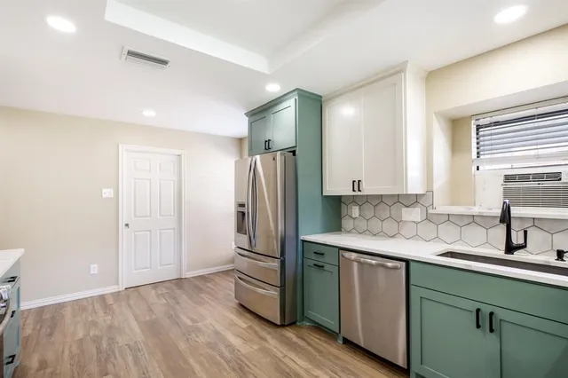 a kitchen with a sink a refrigerator and wooden floor