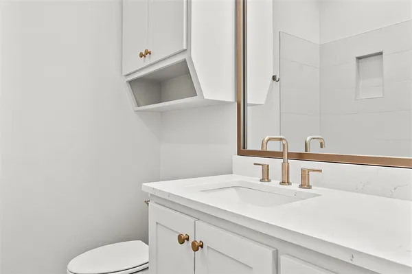 a bathroom with a toilet sink and mirror