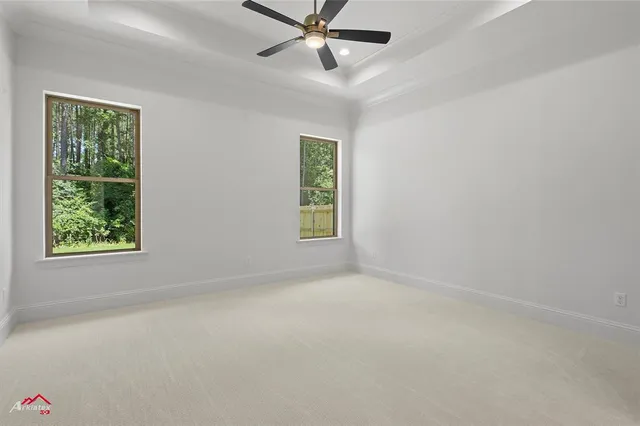 an empty room with a window and a ceiling fan