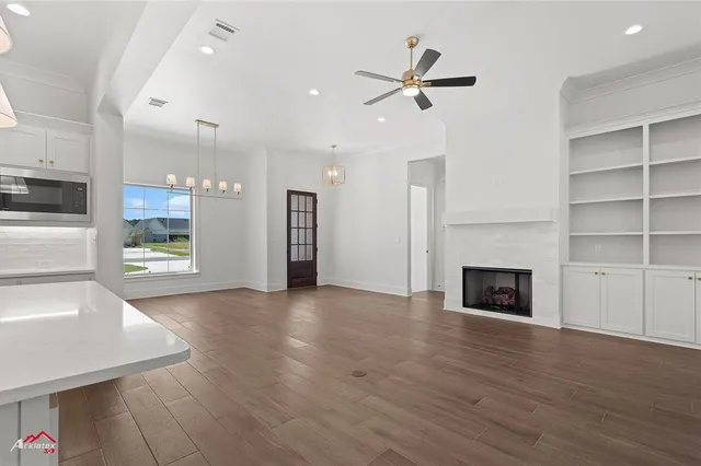 a view of a kitchen with a sink a fireplace and wooden floor