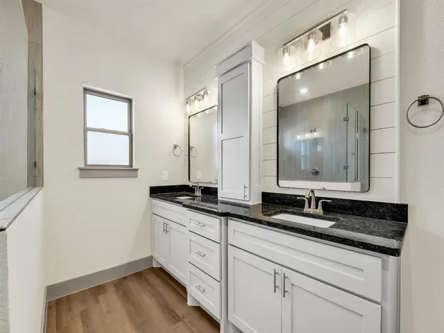 a bathroom with a granite countertop sink a large mirror a and a