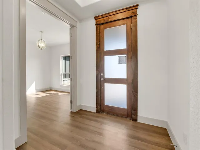 an empty room with wooden floor and a window