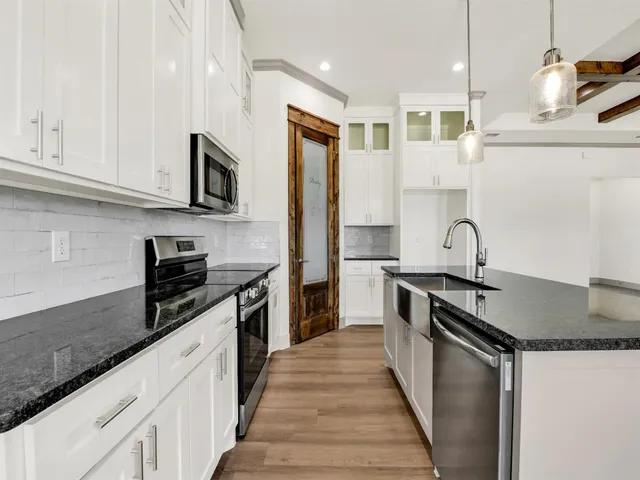 a kitchen with stainless steel appliances granite countertop a sink stove and refrigerator