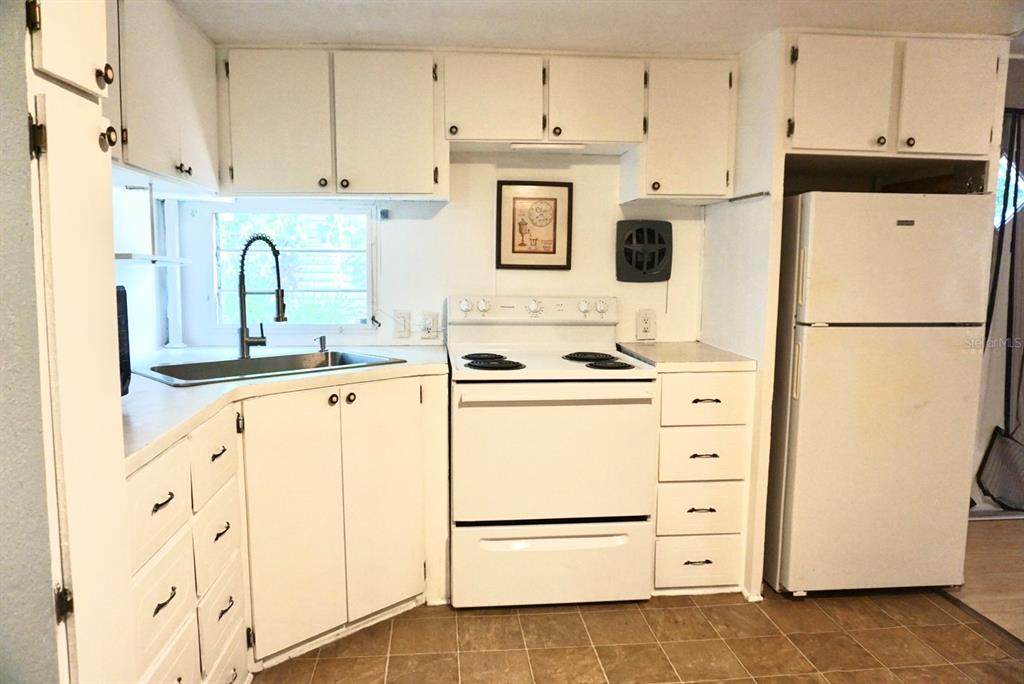 980 7th Street Northwest, Unit 71 Largo, FL 33770 - Photo 9 of 23 a kitchen with stainless steel appliances a refrigerator sink and cabinets