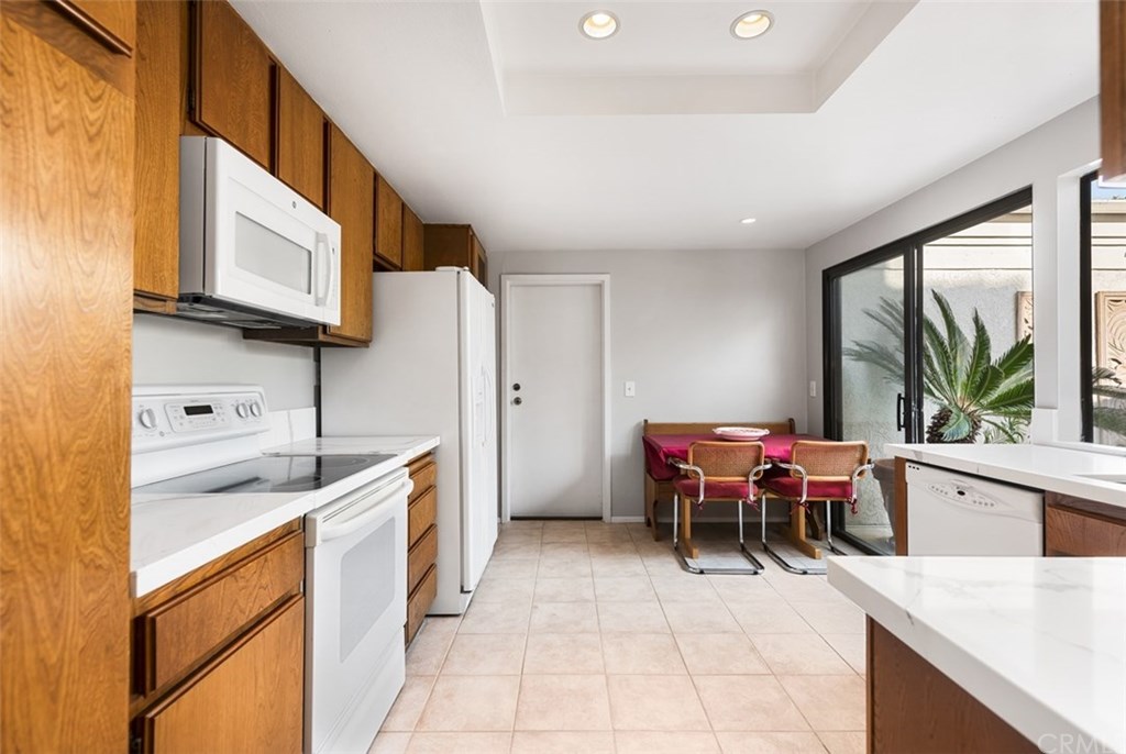 45 Morena Irvine, CA 92612 - Photo 11 of 49 Spacious kitchen with upgraded Quartz Counters, back splash, single basin stainless steel sink, newer microwave, and recessed lighting. *Note the direct access door to garage and sliding door to Interior Atrium.