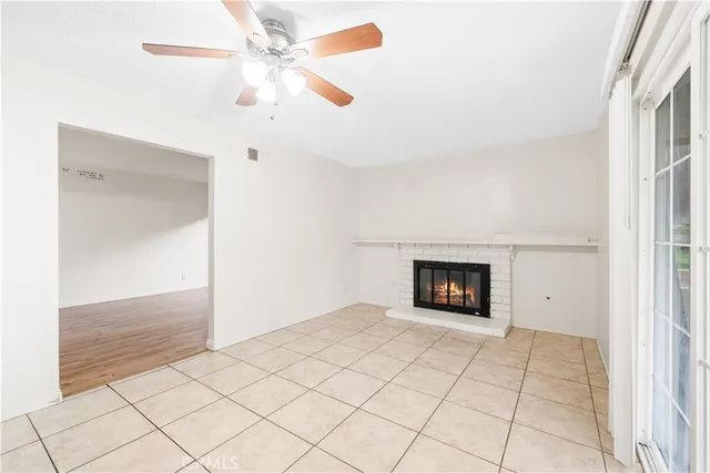 an empty room with a ceiling fan and a window