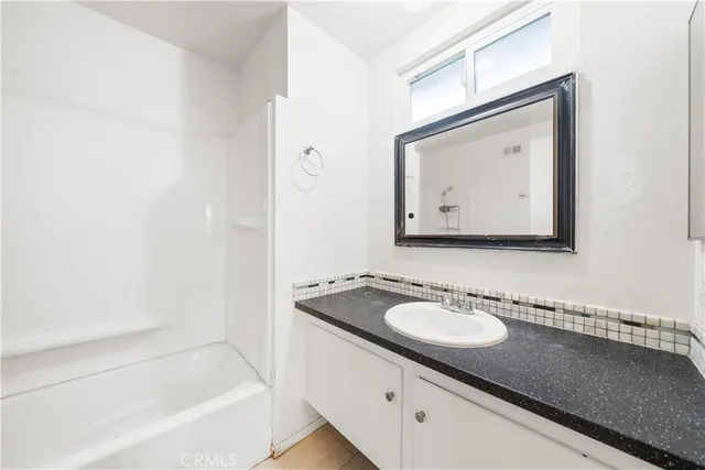 a bathroom with a granite countertop sink and a mirror