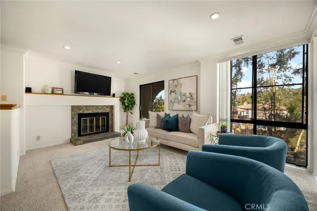 a living room with furniture a large window and a fireplace