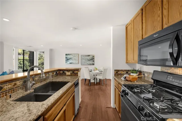 a kitchen with stainless steel appliances granite countertop a stove and a sink