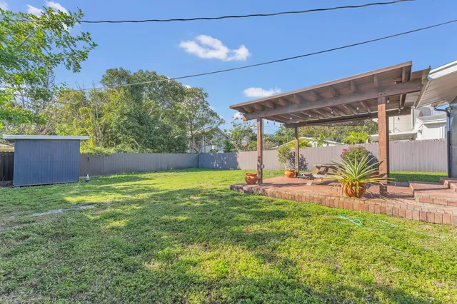 a view of a backyard with table and chairs under an umbrella