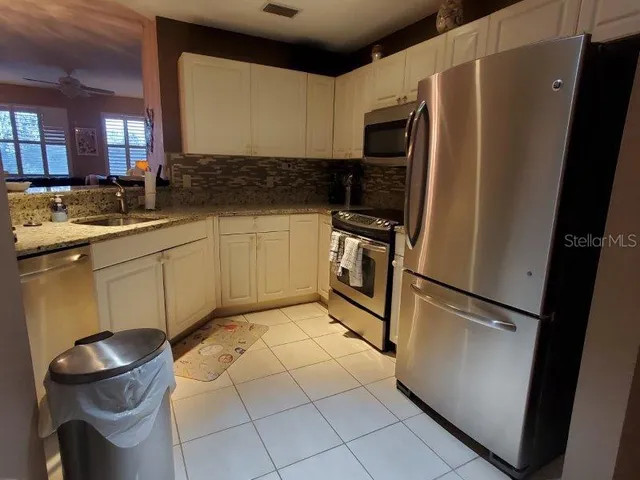 a kitchen with a refrigerator sink and cabinets