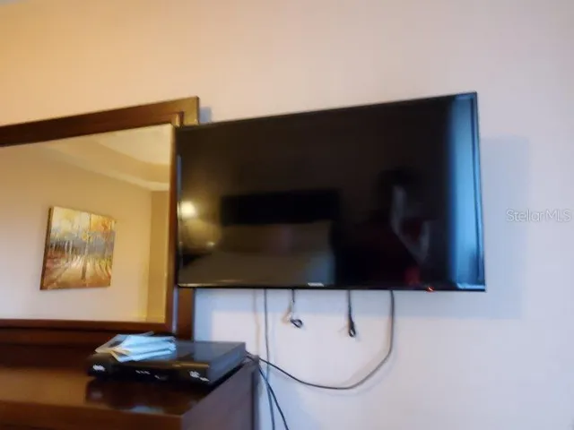 a bedroom with a bed and a lamp on dresser