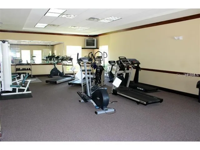 a view of a swimming pool with a bench and trees in the background
