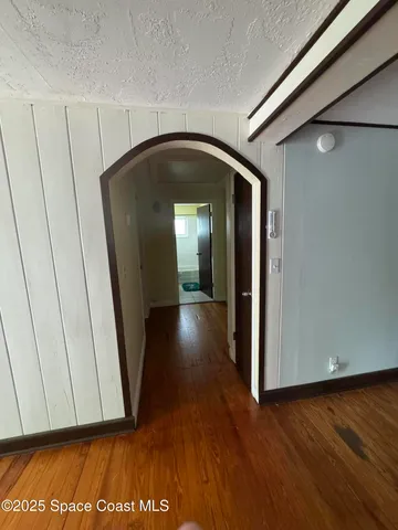 a view of a hallway with wooden floor