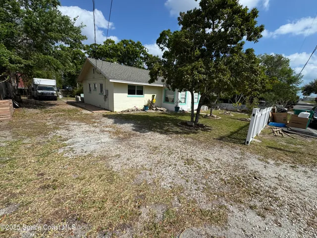 a backyard of a house with barbeque oven table and chairs