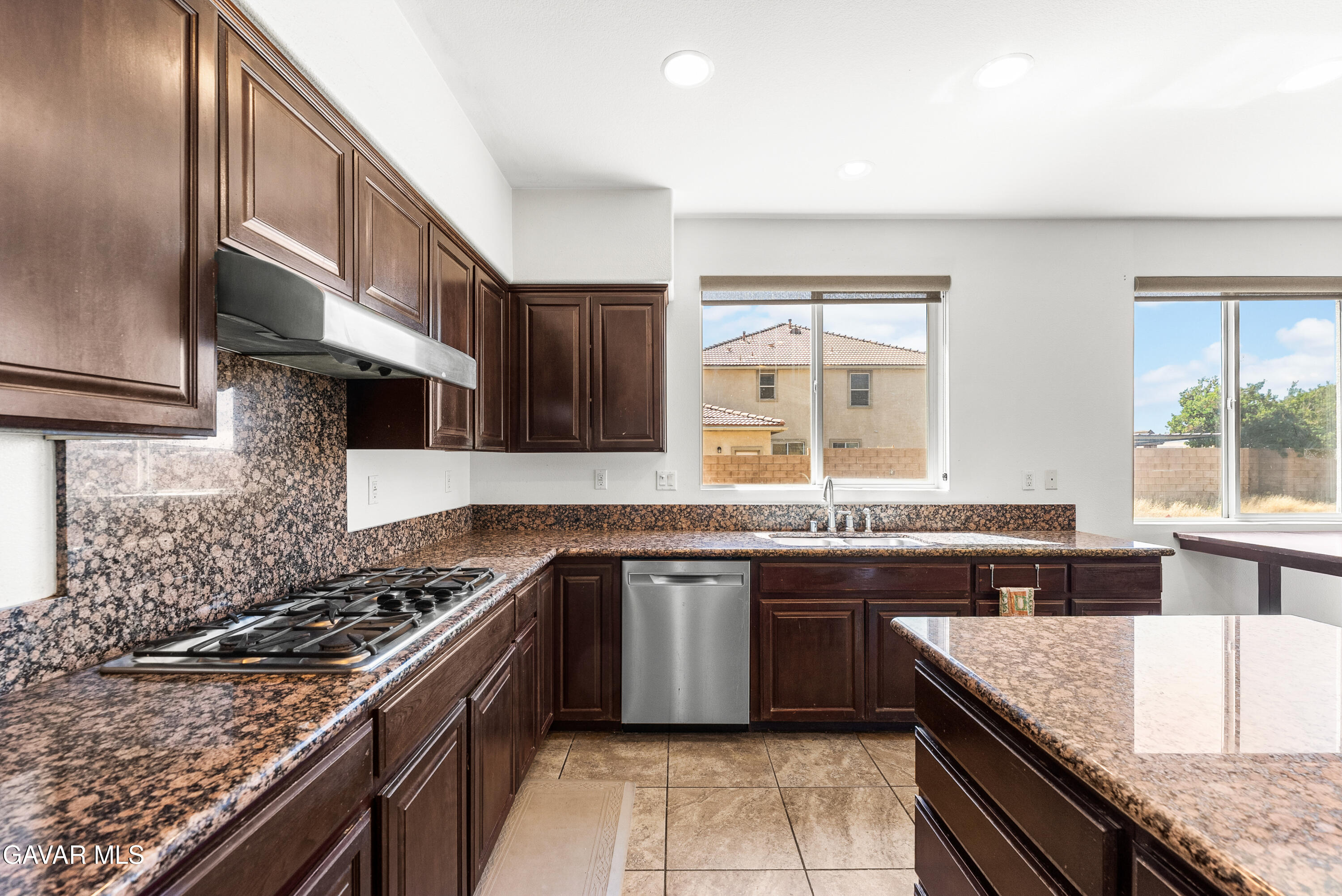 658 Lago Lindo Road Palmdale, CA 93550 - Photo 35 of 91 a kitchen with stainless steel appliances granite countertop a stove a sink and a microwave