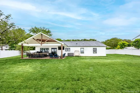 a view of a house with a big yard and large trees
