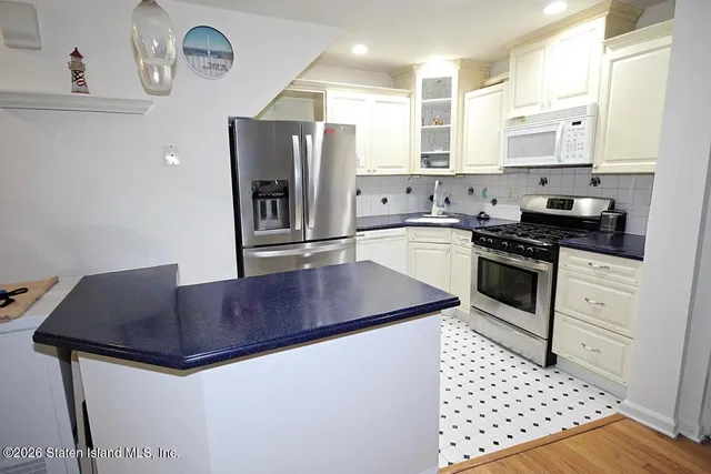 a kitchen with granite countertop a sink cabinets and stainless steel appliances