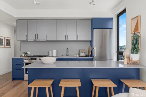 a kitchen with stainless steel appliances a table chairs and wooden cabinets
